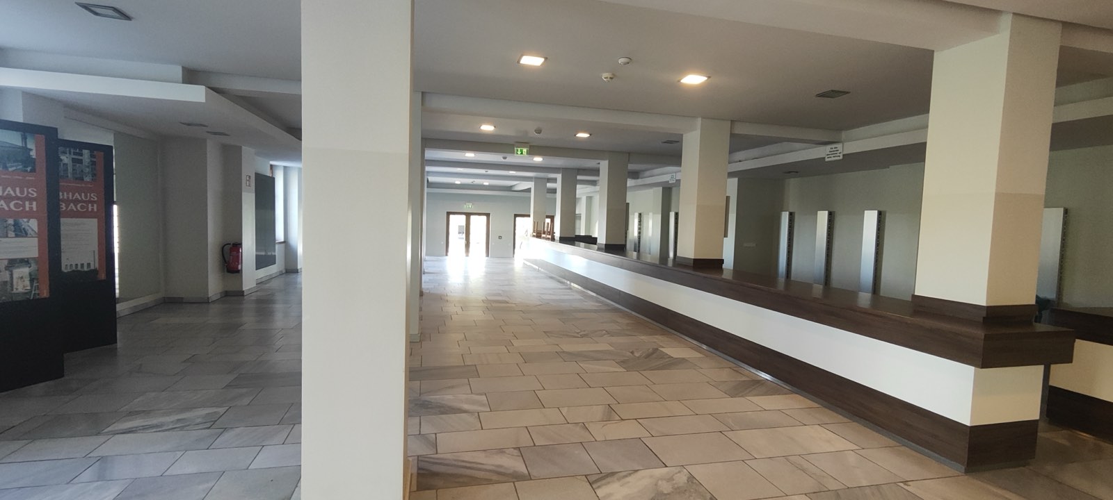 Das weite Foyer mit Garderobentresen und Säulen